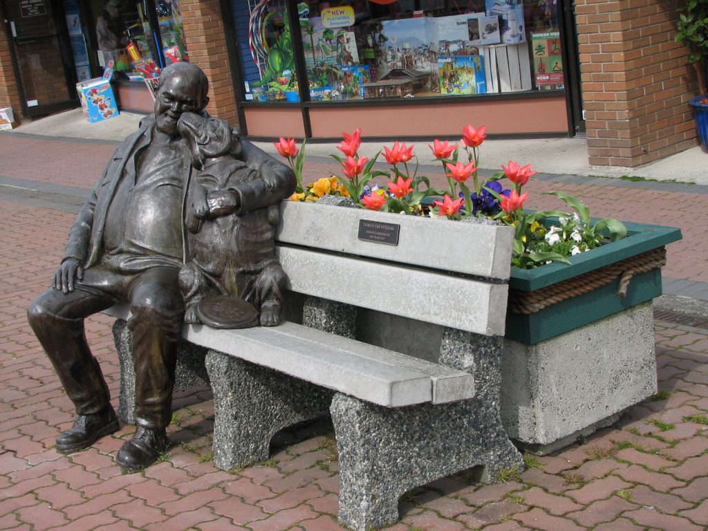 man with dog bench statue