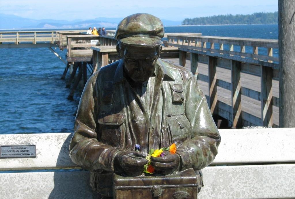  old man statue on bench in front of pier