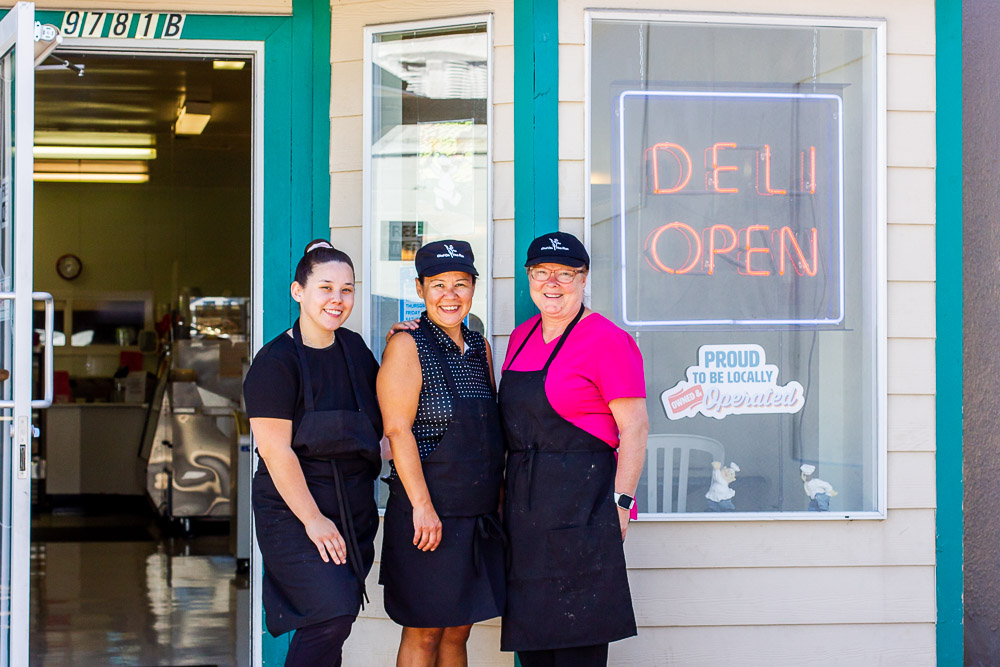 Staff standing outside of Chef on the Run business with sign that says Deli Open