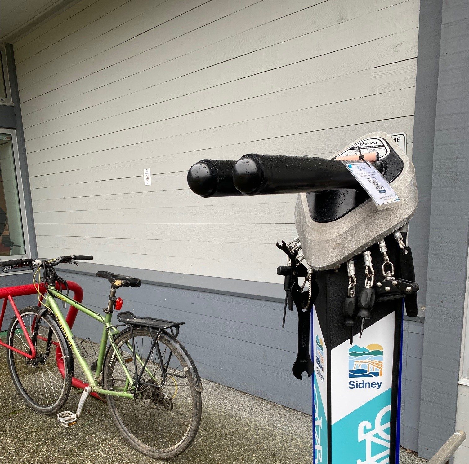 Bike repair station next to bike locked to bike rack.