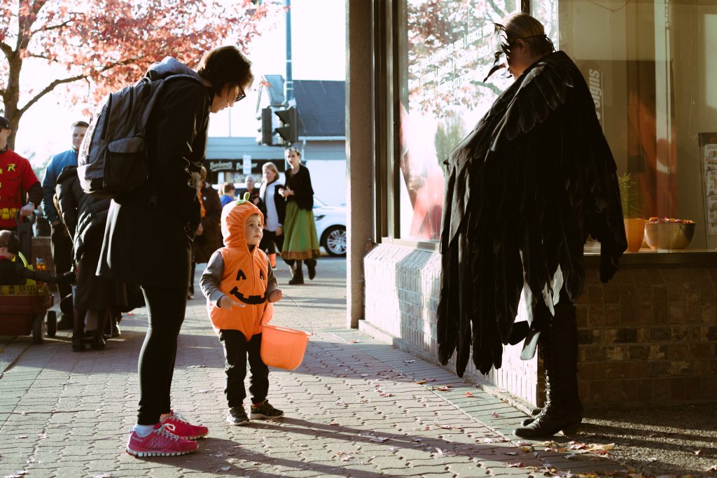 Child trick or treating in pumpkin costume
