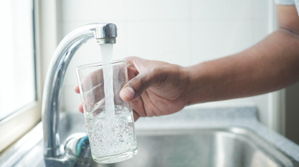 image of kitchen faucet filling up a glass of water