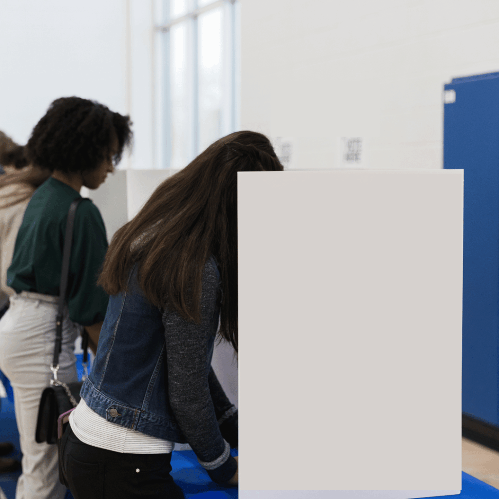 Stock photo of people using privacy screen to vote