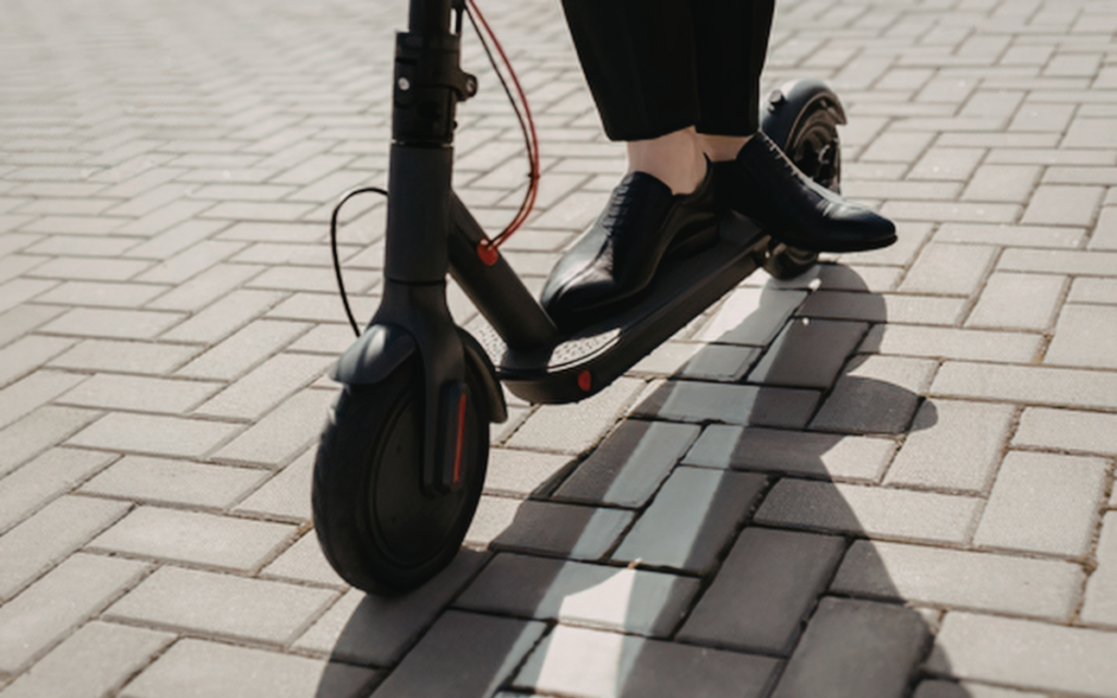 Stock image of scooter showing shoes of rider