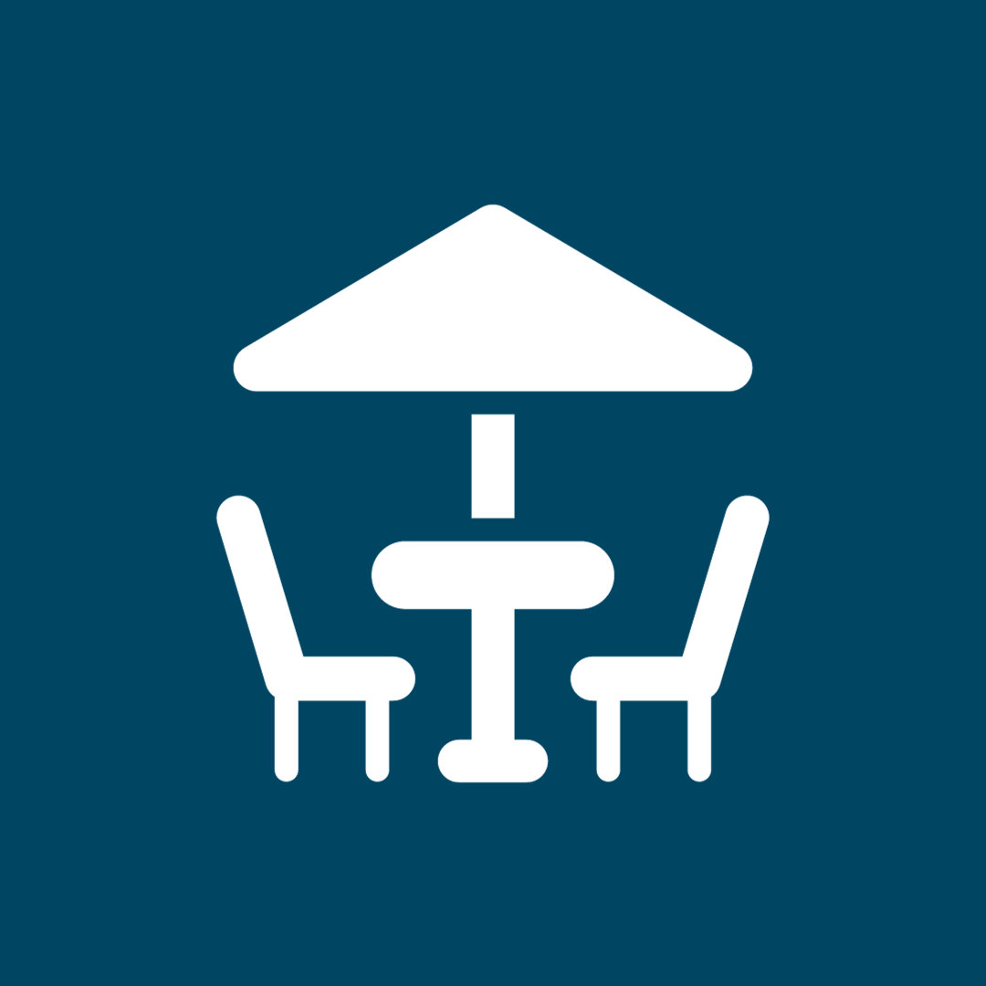 Icon with two chairs and table under patio umbrella