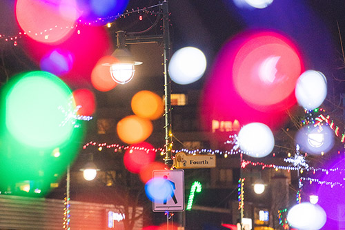 Out of focus Christmas lights in front of the street sign for Fourth Street.
